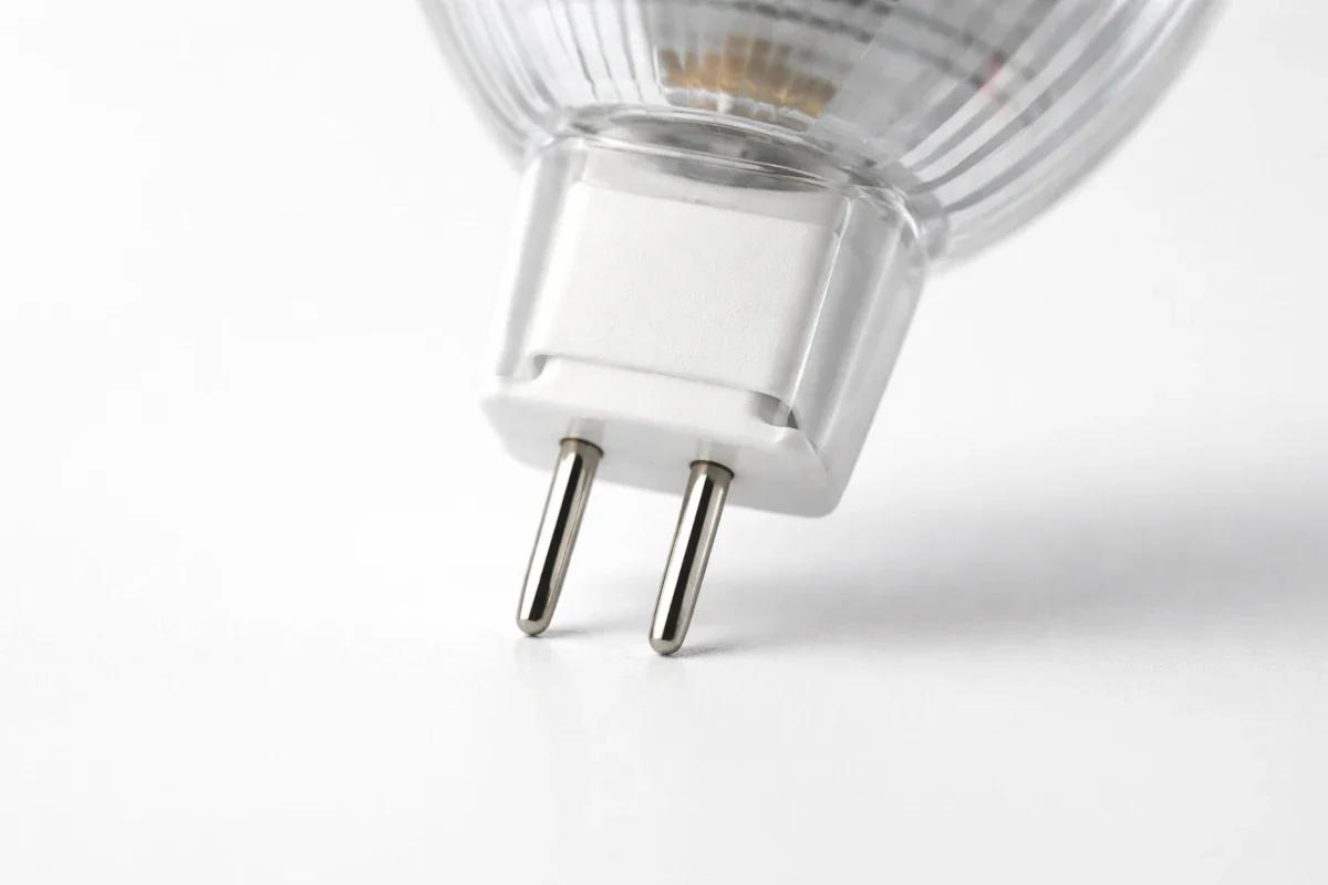 GU4 Sockel erkennen: 4 mm Pin-Abstand – geeignet für 12-V Mini-Spots und LED-Ersatz. Makroaufnahme eines GU4 LED-Stiftsockels mit zwei Pins im Abstand von 4 mm auf hellem Studiohintergrund.